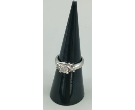 A Tiffany inspired 14ct white gold and diamond set ring. Centre round cut diamond [0.50ct] off set with a single Princess cut