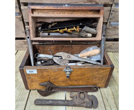 A small wooden tool chest containing vintage tools. 