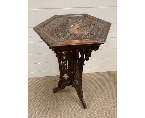 A plant stand or occasional table with decorative inlay.