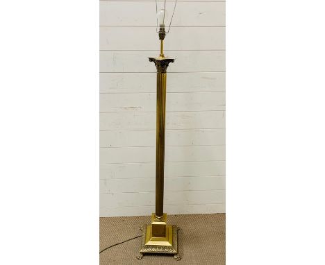 A Floor standing brass column light on lion claw feet.