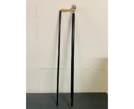 A pair of walking sticks, one with bone handles another with inset compass 