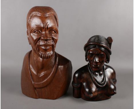 An African caved wooden head and shoulder bust of a man from one single piece of wood. Height 43cm, width 26cm, and a wooden 