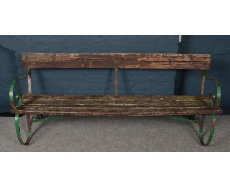 A vintage wood and iron garden bench with scrolling supports. (Length 187cm).  