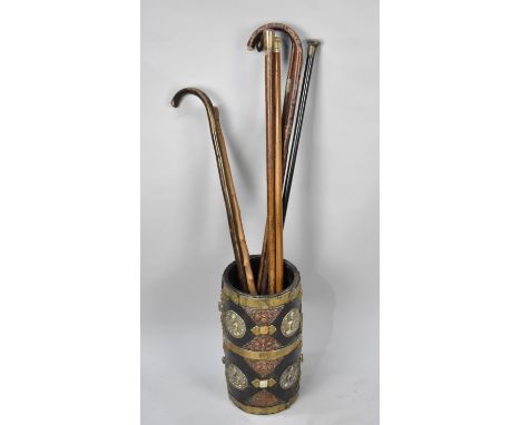 A Burmese Brass Mounted and Jewelled Cylindrical Stick Stand, 19cms Diameter and 37.5cms High Containing Various Silver Mount