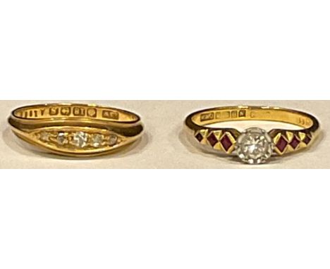 An 18ct gold diamond solitaire ring, graduated cushion cut rubies to shoulders, Birmingham; an 18ct gold five stone diamond r