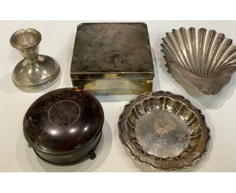 A silver scallop shaped dish, London 1921; a shaped circular trinket dish, Sheffield 1946; a silver candlestick, Birmingham 1