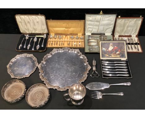 A pair of silver plated bottle coasters, in George III style; two George III style salvers; a quantity of flatware; etc 