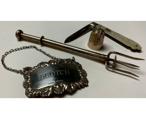 A silver pickle fork, Birmingham 1932; a silver and mother of pearl penknife; a silver Scotch decanter label; a silver thimbl