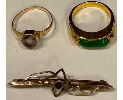 An 18ct gold ring, set with a single green stone, size Q, the shank marked 18k, 5.3g; an unmarked amethyst and gold ring, siz