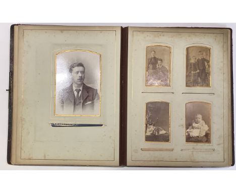 Photography - an Edwardian leather bound carte de visite album, containing various single and grouped portrait photographs (a