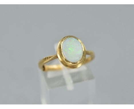 A LATE 20TH CENTURY SINGLE STONE OPAL RING, oval rub over set white opal measuring approximately 10mm x 8mm, ring size R1/2, 