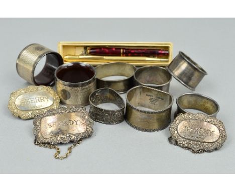 EIGHT MIXED SILVER NAPKIN RINGS, approximate weight 157 grams, three silver decanter labels, Sherry, Whisky, Brandy