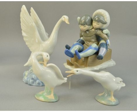 A LLADRO FIGURE GROUP, 'Hang On' boy and girl on sledge, No5665, together with two Lladro geese and a Nao goose 94)