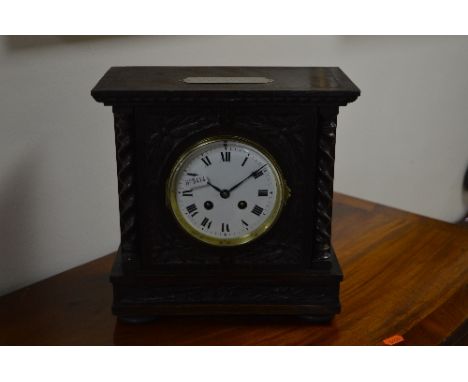 AN EARLY 20TH CENTURY CARVED OAK MANTEL CLOCK, the brass movement stamped Japy Freres, the circular dial with Roman numerals 