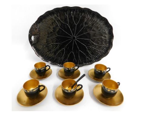 A Japanese gilded lacquerware set of cups &amp; saucers twinned with an early 20thC. lacquerware tray of organic form, 18in w