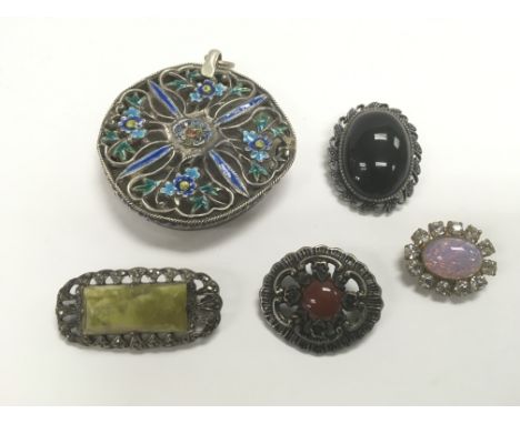 A large jade pendant with enamelled decoration together with four brooches (5).