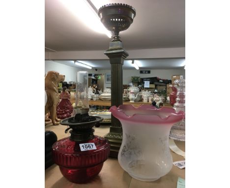 A Victorian brass oil lamp With cranberry font, glass chimney and shade