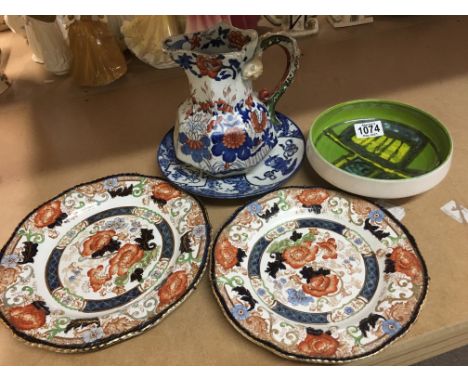 A green Poole pottery dish together with three decorative plates and ironstone jug