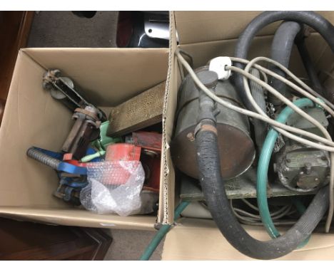 A box containing old fuel cans a green enamel mincer old lamps lights and tins and a vintage pump. (a lot)