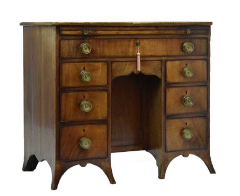 Early 19th century inlaid and crossbanded mahogany kneehole dressing table/desk, the rectangular top with canted front corner