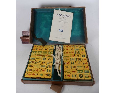 A mid 20th century composite mahjong set, in fitted tan leather case, width 34cm (not checked for completeness), together wit