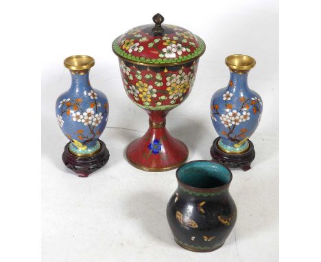 A Chinese cloisonne enamel pedestal cup and cover, decorated with prunus blossom on a red ground, h.21cm, together with a pai