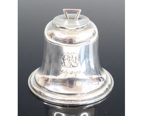 A George V silver inkwell of bell shape, the hinged cover opening to a ceramic well with gilt washed interior, the body with 