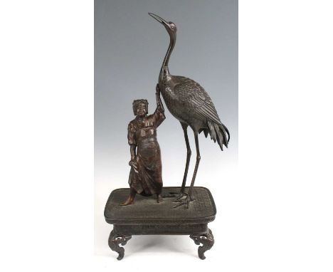 A large Japanese Meiji Period (1868-1912) bronze model of a standing robed woman with oversized crane, naturalistically model