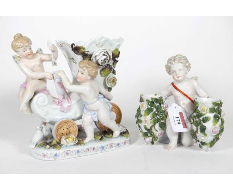 A Sitzendorf porcelain vase, modelled as a kneeling putti clutching two floral encrusted urns, underglazed mark to the unders