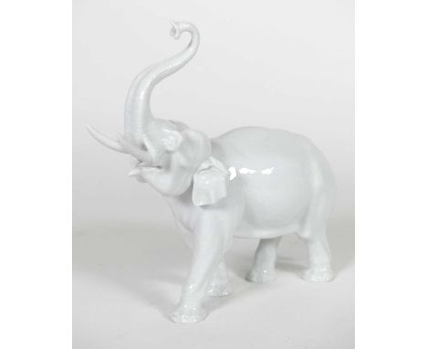 A Meissen blanc de chine porcelain elephant, modelled standing with trunk raised, underglazed blue, impressed marks to the un
