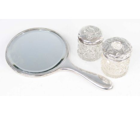 A George V dressing table tidy, having a hobnail cut glass body, the silver cover repousse decorated with scrolling leaves, J
