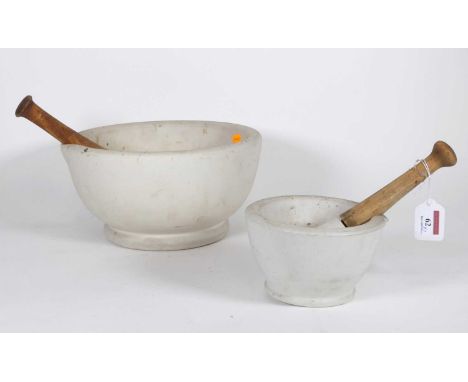 A large stoneware pestle and mortar, the mortar having a turned wooden handle, dia. 28cm, together with another smaller