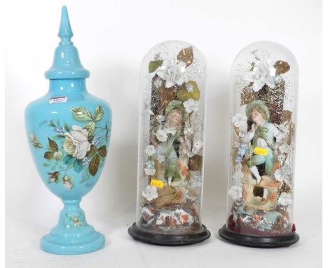 A pair of early 20th century continental bisque porcelain figures of a lady and gentleman, each with floral surround, each ho