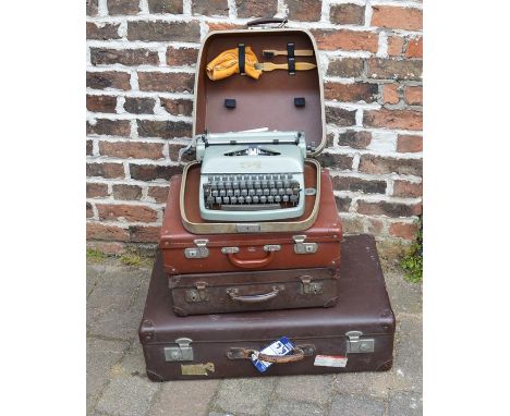 3 vintage suitcases and a portable typewriter