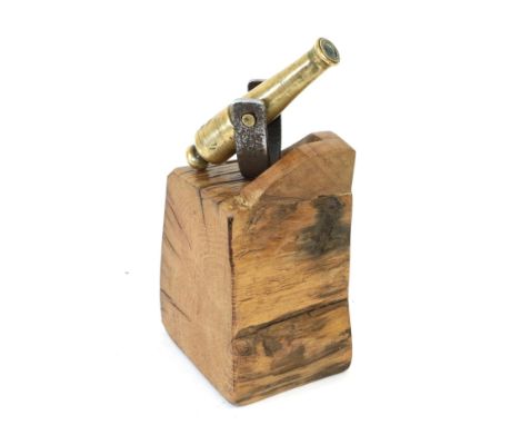 A Small Brass Desk Cannon, the 11cm barrel stamped with broad arrow/V R and mounted on an oak block, 22cm