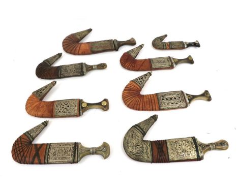 A Collection of Eight Arab Jambiyas, 20th century, each with curved blade with raised medial ridge, horn grip and leather sca