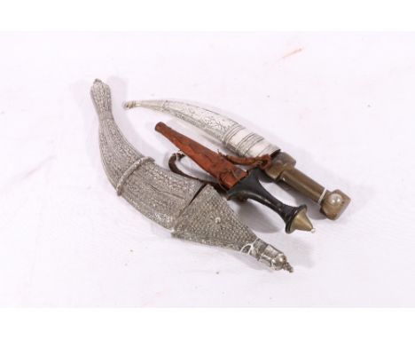 Sudanese arm dagger, a Caucasian dagger in white metal sheath and an Eastern knife with relief decorated white metal grip and