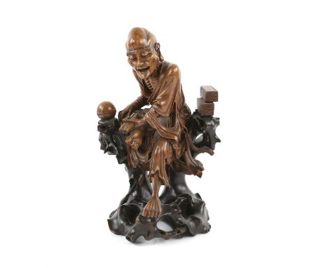 Chinese carved hardwood figure of a seated old man holding a scroll, on integral base, 30.5cm high,