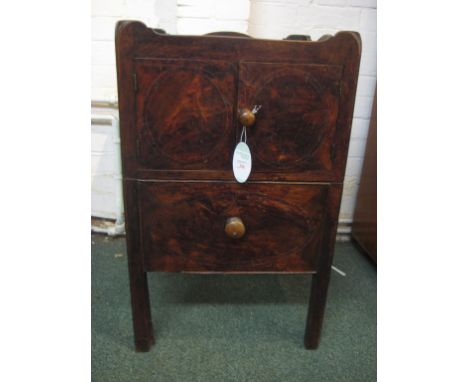 A dark stained wood commode with tray top, drawer-pull front with china basin and turned wooden cover beneath a two door cupb