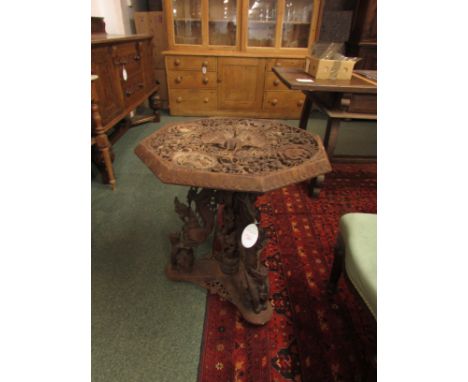 A heavily carved hardwood Taiwanese octagonal occasional table. To the centre of the table there is an intricately carved pea