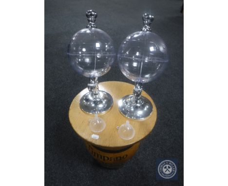 A barrel stool together with two globe drinks dispensers 