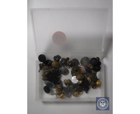 A box containing military and service buttons and badges, miner's lamp token, military tag etc