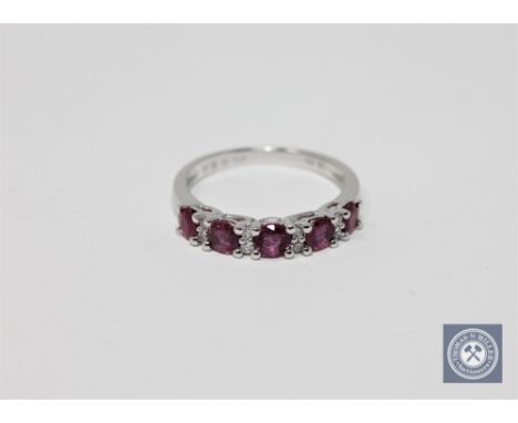 A 14ct white gold ruby and diamond ring featuring five round cut natural rubies 0.98ct with eight round brilliant cut natural
