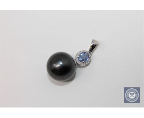 A 14ct white gold pearl and diamond pendant featuring one cultured Tahitian pearl with one oval cut natural sapphire 0.39ct w