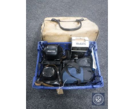 A canvas bag containing cameras to include Zenit and Practika, lens and flash