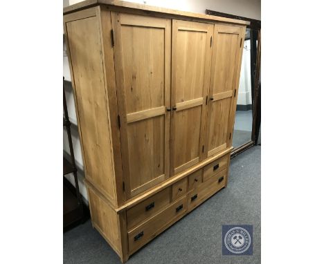 A contemporary light oak triple door wardrobe fitted with six drawers, width 161 cm 