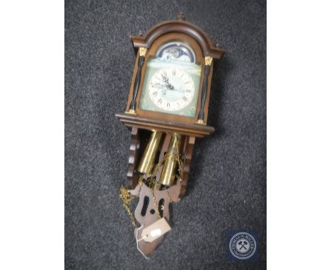 An oak sun and moon phase wall clock with pendulum and weights 