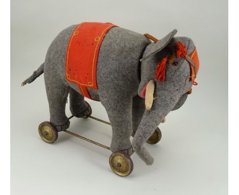 A good grey felt Schuco Roller Yes/No Elephant on wheels, German 1920s, with orange glass eyes, white cloth tusks, large ears