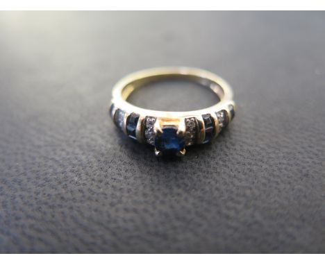 A 14ct yellow gold sapphire and diamond ring size L - centre sapphire approx 4mm x 3mm - weight approx 2.8 grams - clean cond