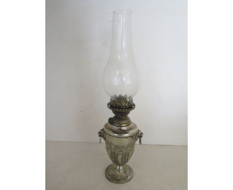 A silver plated small oil lamp with glass chimney lion mask ring handles on single pedestal with engraved foliate finish 